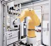 Gelber Roboter-Arm in einer Produktionszelle